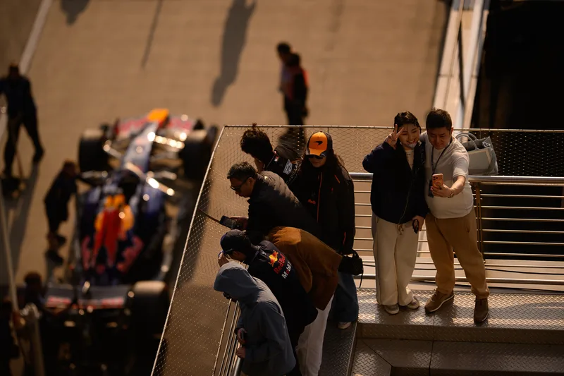 Guests on a walkway above the Formula 1 cars.